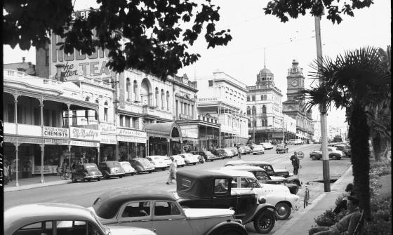 Busy street lined with building and parked cars