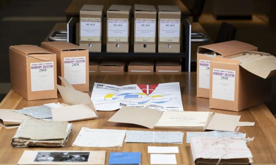 Cardboard boxes and manuscript material spread over a large table