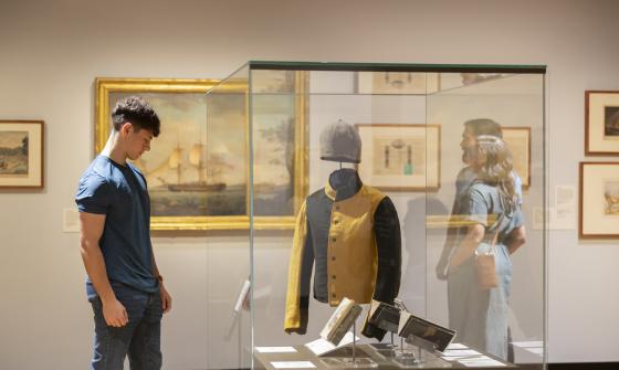 Young man looking at convict uniform on display in the gallery