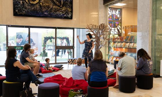 Author Kathy Weeden reading and acting out her book 'Phonobet' to children and their parents in the foyer during Enlighten