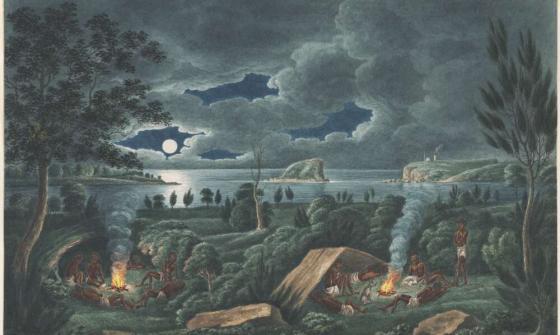 A landscape showing a group of people gathered around two campfires. Some sit and lie near the fires, while others stand. Smoke rises from the fires into the night sky. A body of water and distant cliffs are visible under a moonlit, partly cloudy sky.