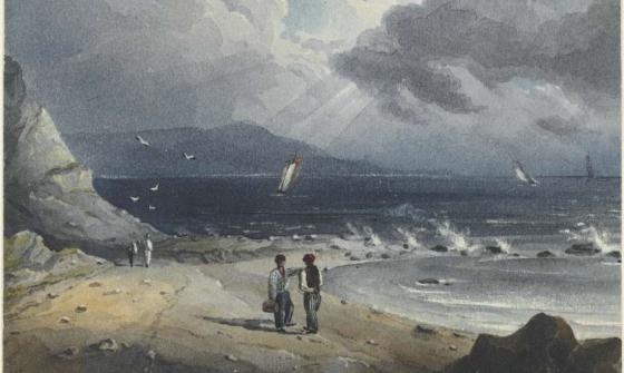 A beach on an overcast day with a stream of sunlight and water crashing on rocks. 4 people on the beach in 2 groups with 3 small boats in the background. 