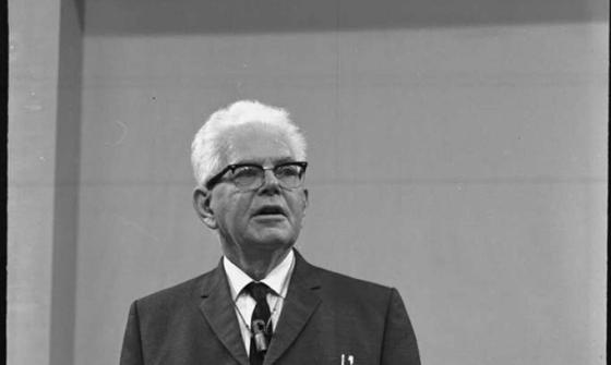 black and white photograph of a man lecturing at a lecturn