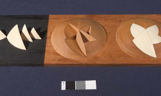 A stylised, abstract architects model of the Sydney Opera House. The model shows a hemisphere with triangular segments removed, another hemisphere shows the segments replaced to create a smooth surface.