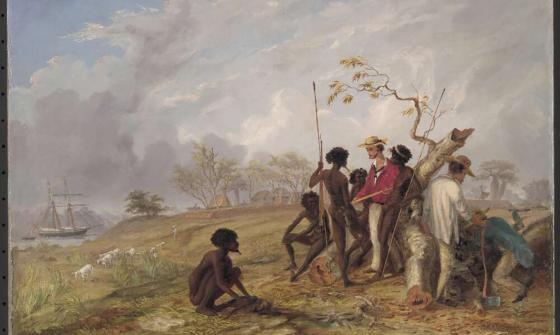 A group of men are gathered around a fallen tree in an outdoor setting. One person is seated on the ground, while others stand and hold spears. Two individuals engage in manual labor. A ship is anchored near the shore in the background, with sheep grazing on the grassy landscape. The sky is partly cloudy, and there are trees and a small structure in the distance. This scene depicts a moment of cultural interaction and shared labor during a historical period of exploration and colonisation.