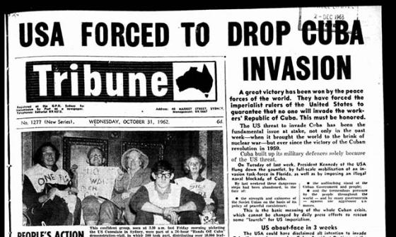 The front page of the Tribune newspaper. The headline reads 'USA FORCED TO DROP CUBA INVASION'. There is a black and white photograph of 5 people holding protest signs.