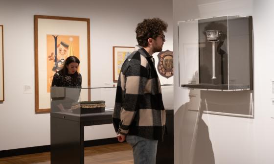 People looking at items on display, including an Olympic torch, in the Exhibition Gallery at the National Library