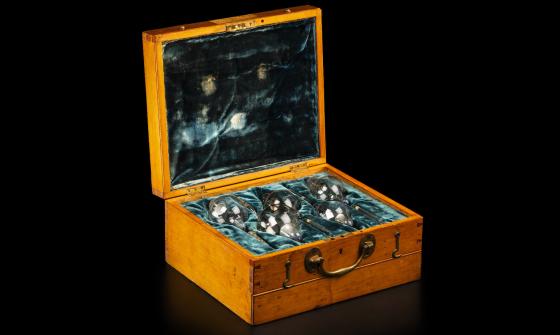Glass x-ray bulbs/tubes laid on teal velvet in a wooden box