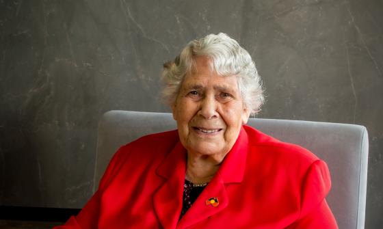 Dr Lowitja O'Donoghue sitting in an armchair and smiling