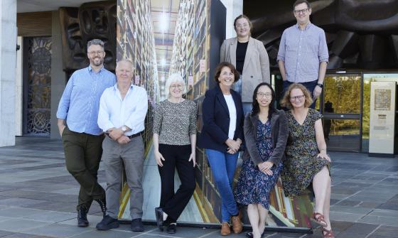 Group of men and women, standing and sitting together on the National Library podium