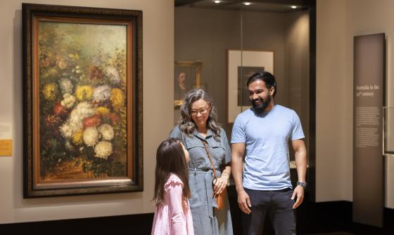 Parents and child smiling and talking in the Library's Treasures Gallery