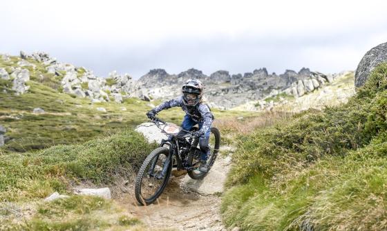 Mountain biker in full gear riding a rocky, dirt path
