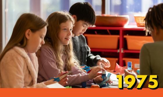 Children seated at a table doing craft activities