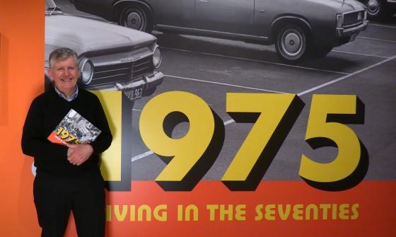 Guy Hansen holding a book in the 1975 exhibition gallery