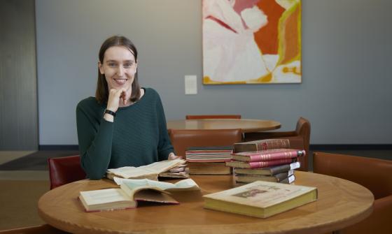 Dr Jorien van Beukering sitting at a table with books across it.