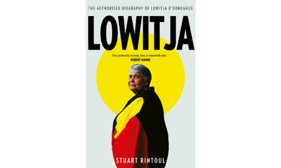 Cover of 'Lowitja : the authorised biography of Lowitja O'Donoghue' which features a photo of Lowitja O'Donoghue with the Aboriginal flag draped around her