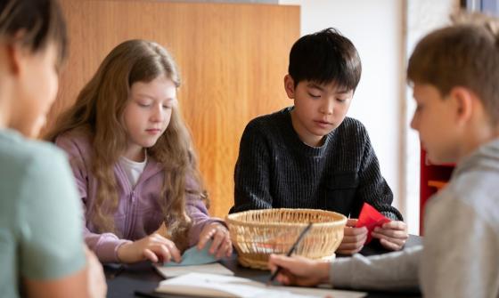 Children seated at a table doing craft activities