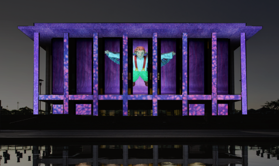 An illumination of the National Library of Australia building, showcasing a figurine with wings