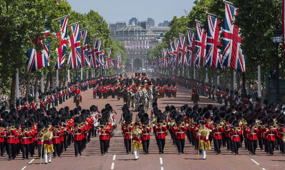 A marching military band and parade with many instruments and United Kingdom flags