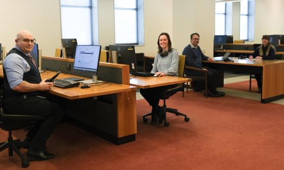 Four members of the Library's Special Collections Research & Support team, two men and two women, sitting at tables in the Main Reading Room