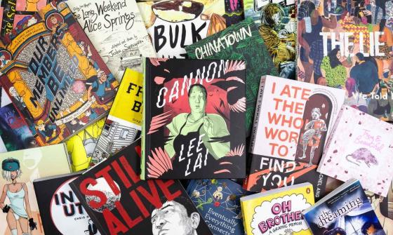 A pile of comics and graphic novels scattered over a table