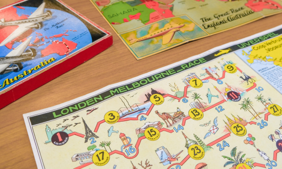 Two colourful board games relating to the 1934 MacRobertson International Air Race on a wooden table