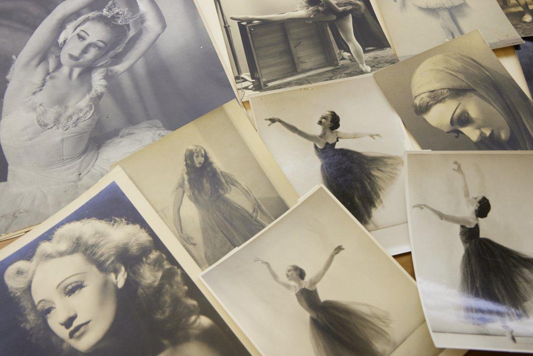 Photographs spread on a table, of a woman throughout her career in ballet, including photos of her dancing and portraits