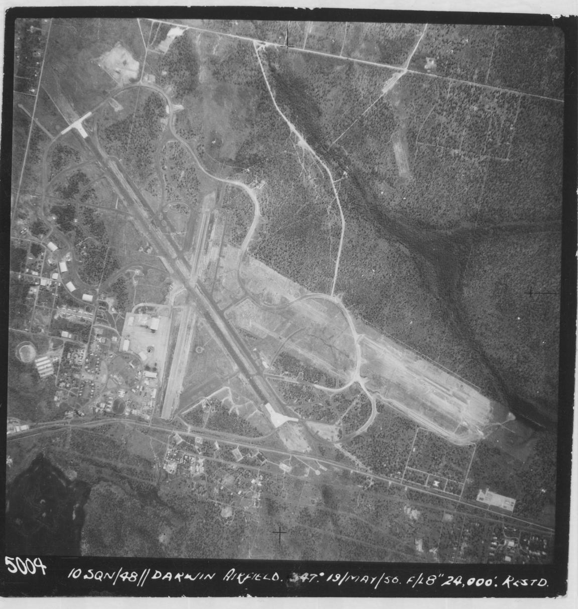 Aerial view of Darwin Airfield, 1956, showing runways, surrounding facilities, and natural terrain.
