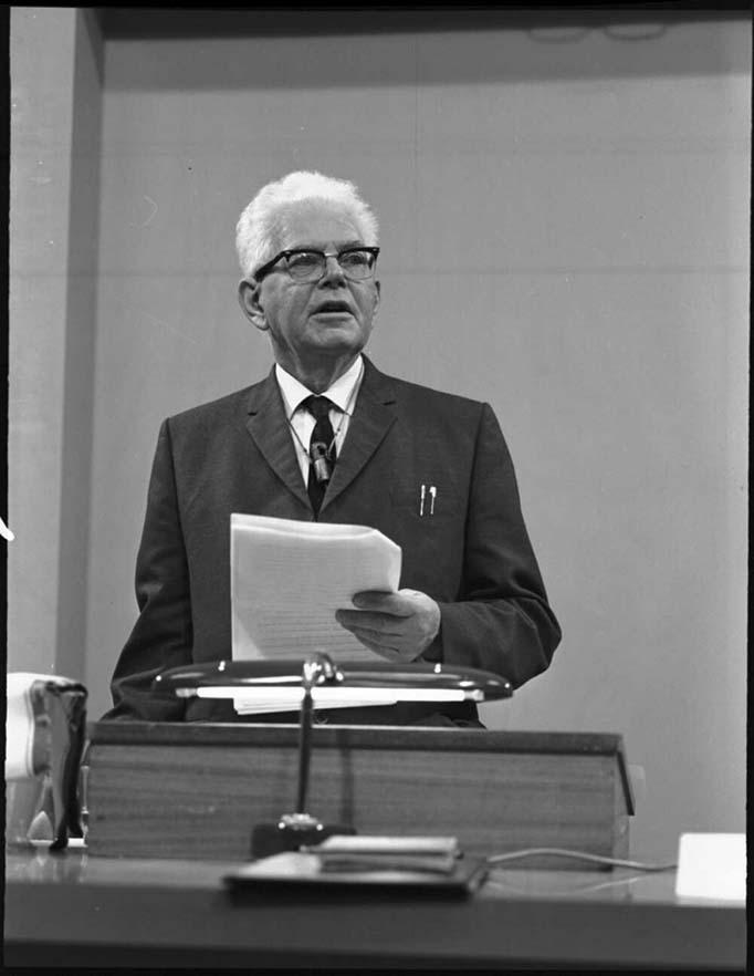 black and white photograph of a man lecturing at a lecturn