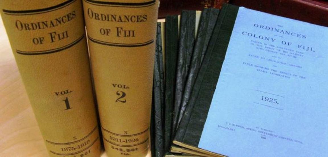 A picture of 2 leather bound books side by side and one bound set of papers.