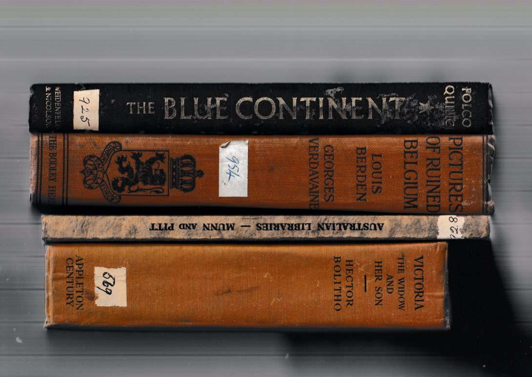 A stack of old books with brown and black spines