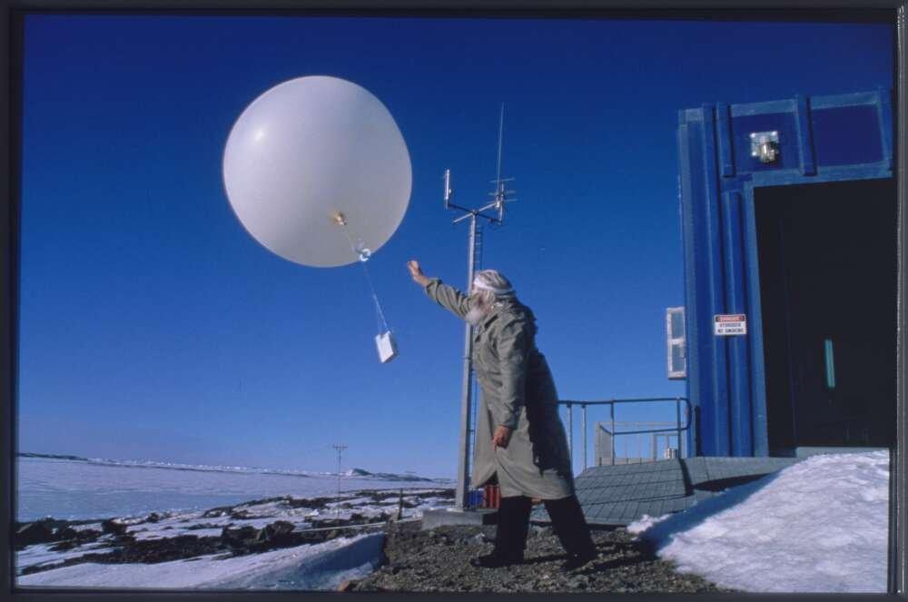 photo of a man releasing a weather balloon in an icy environment