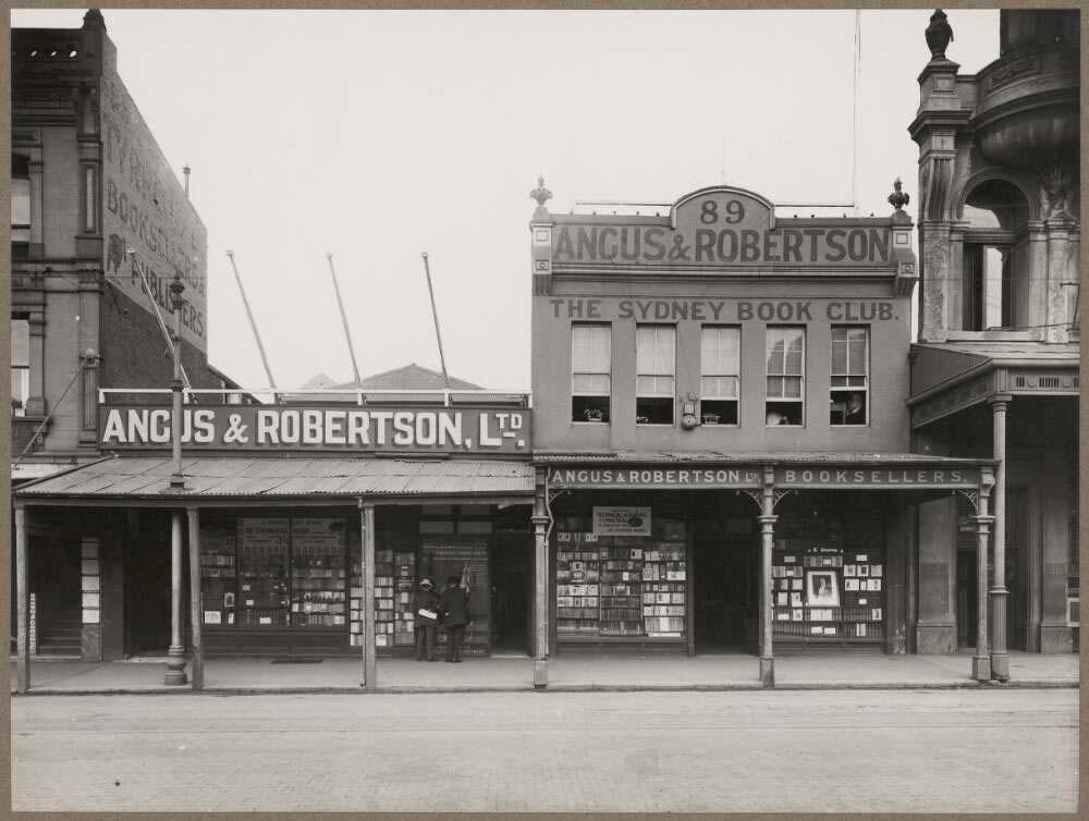 black and white photo of an old building with Angus & Robertson on the sign