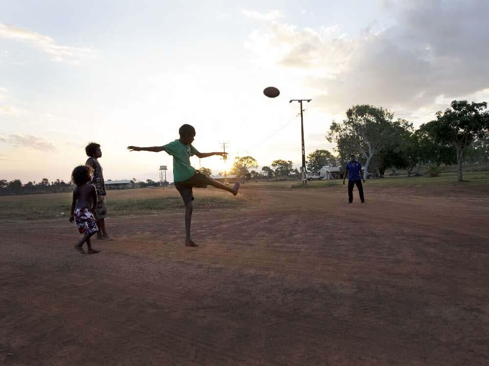 Photo of Aboriginal children playing football, Wudikapildiyerr outstation, Daly River, Northern Territory, 25 June 2010