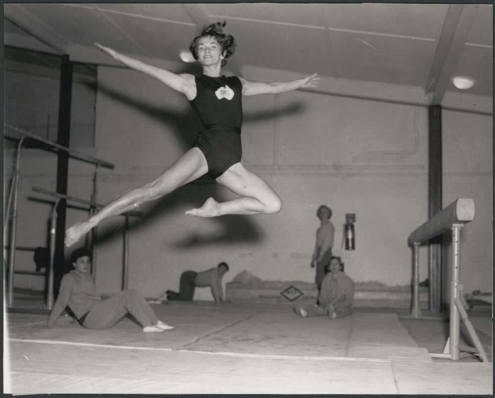 black and white photo of a gymnast leaping in the air