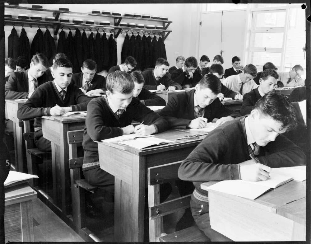 boys sitting at desks in a school classroom