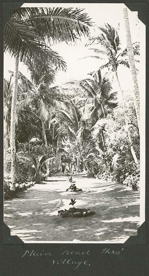 black and white photo of a road through a village