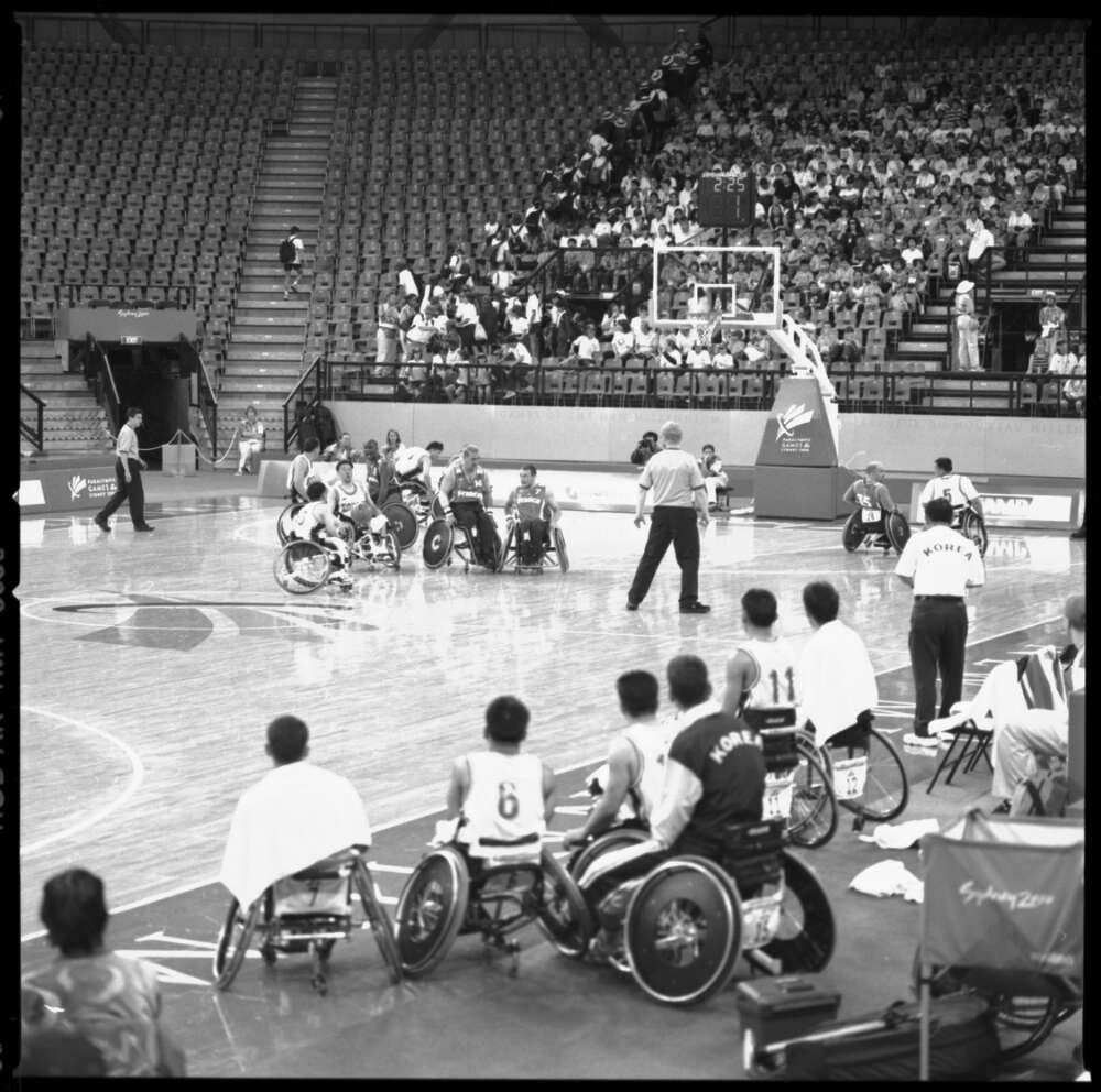 black and white photo of a men's wheelchair basketball match