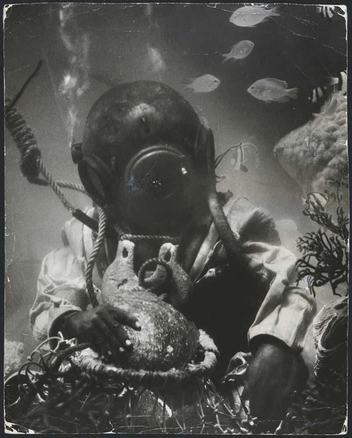 black and white photo of a pearl diver collecting shells from the sea bed