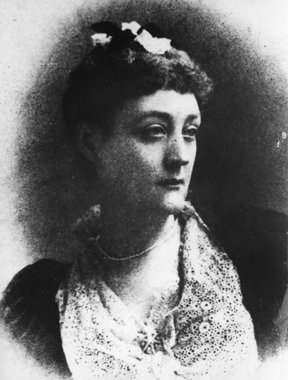 Photo portrait of Rosa Praed, wearing formal closes and looking to her right with a serious face