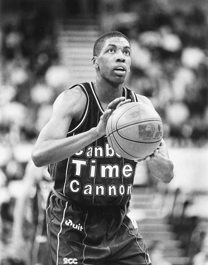 Black and white photo of basketball player, Robert Rose, poised to shoot at the goal