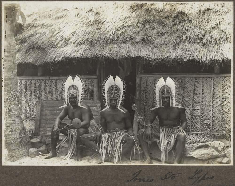 black and white photo of three Islander men wearing head dresses