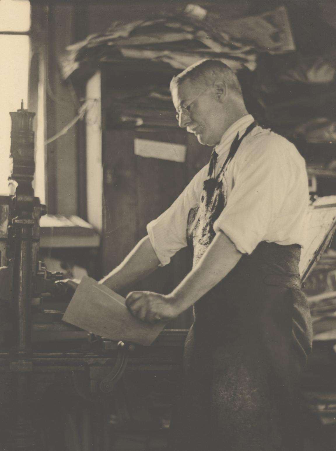 Sepia-toned photo of artist Lionel Lindsay at work in his studio
