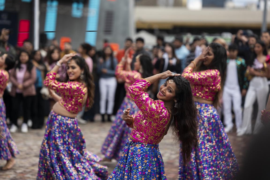 Members of the Bollydance Dipti dance group performing in cultural dress in front of a crowd