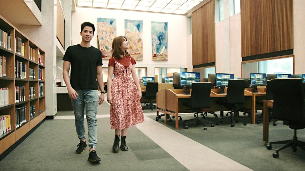 Young man and woman in casual wear walking through the Main Reading Room