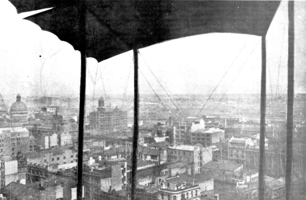 Photograph of lower quality taken from a plane, with it's wing visible, flying over Sydney