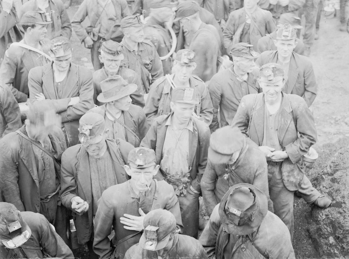 Black and white image of dozens of colliers, or coal miners, in uniform