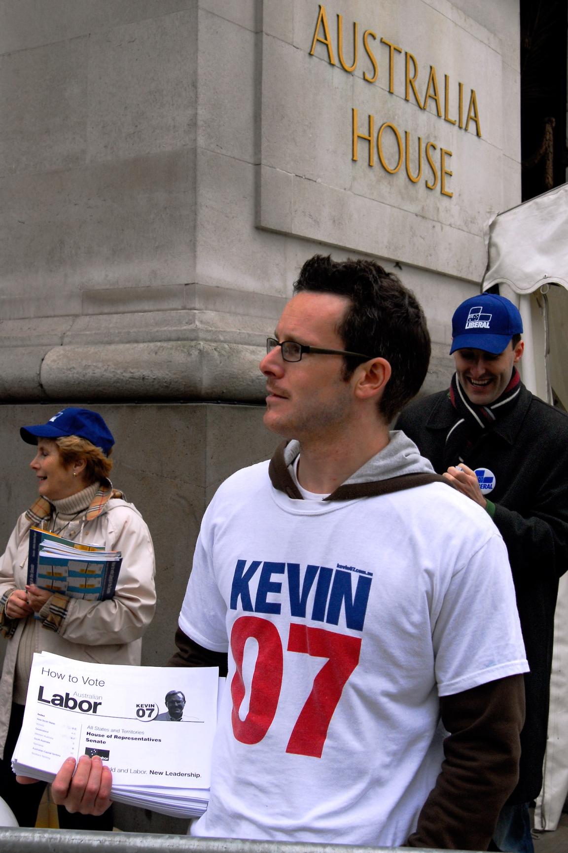 Man wearing a 'Kevin '07' shirt handing out voting information in front of Australia House in London