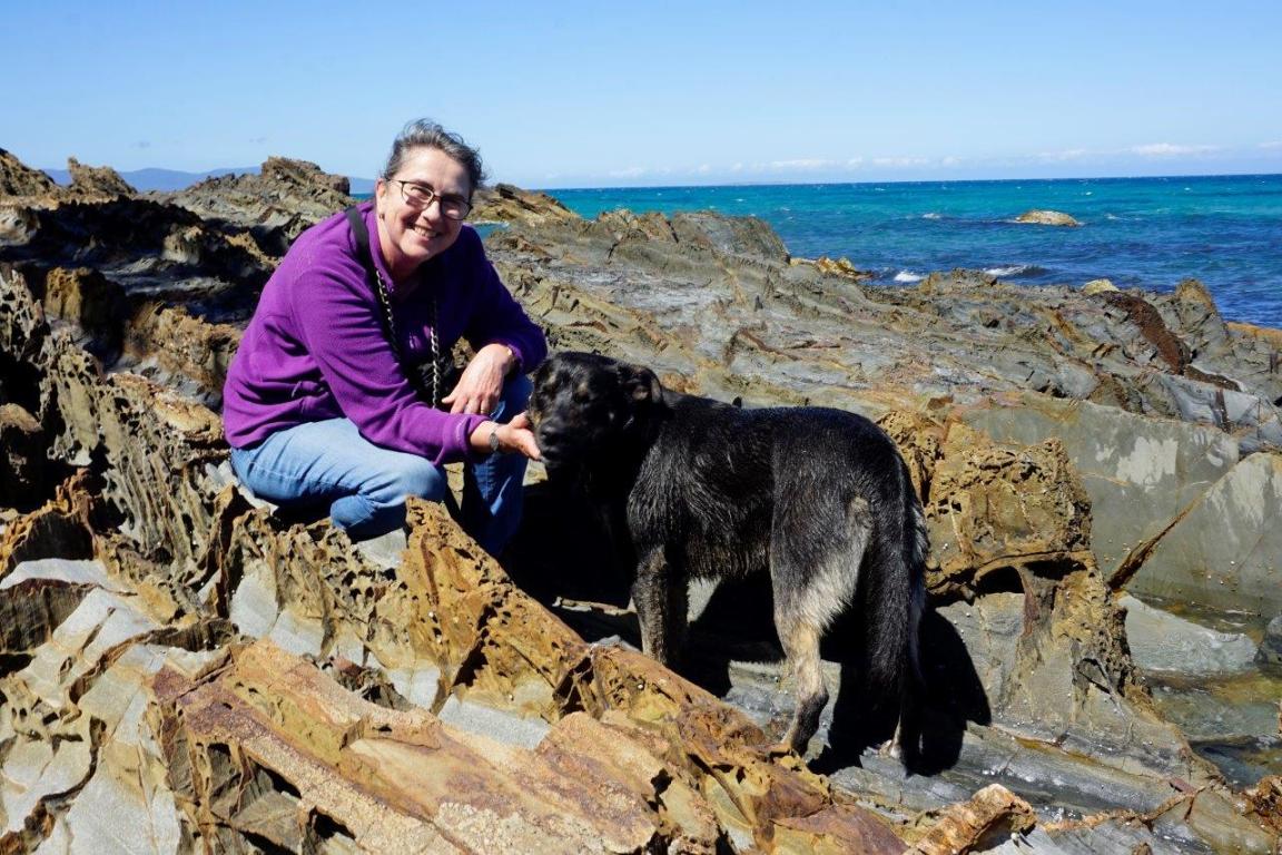 Photo of 'Dog Beach' author at the beach with her dog Banjo on a sunny day