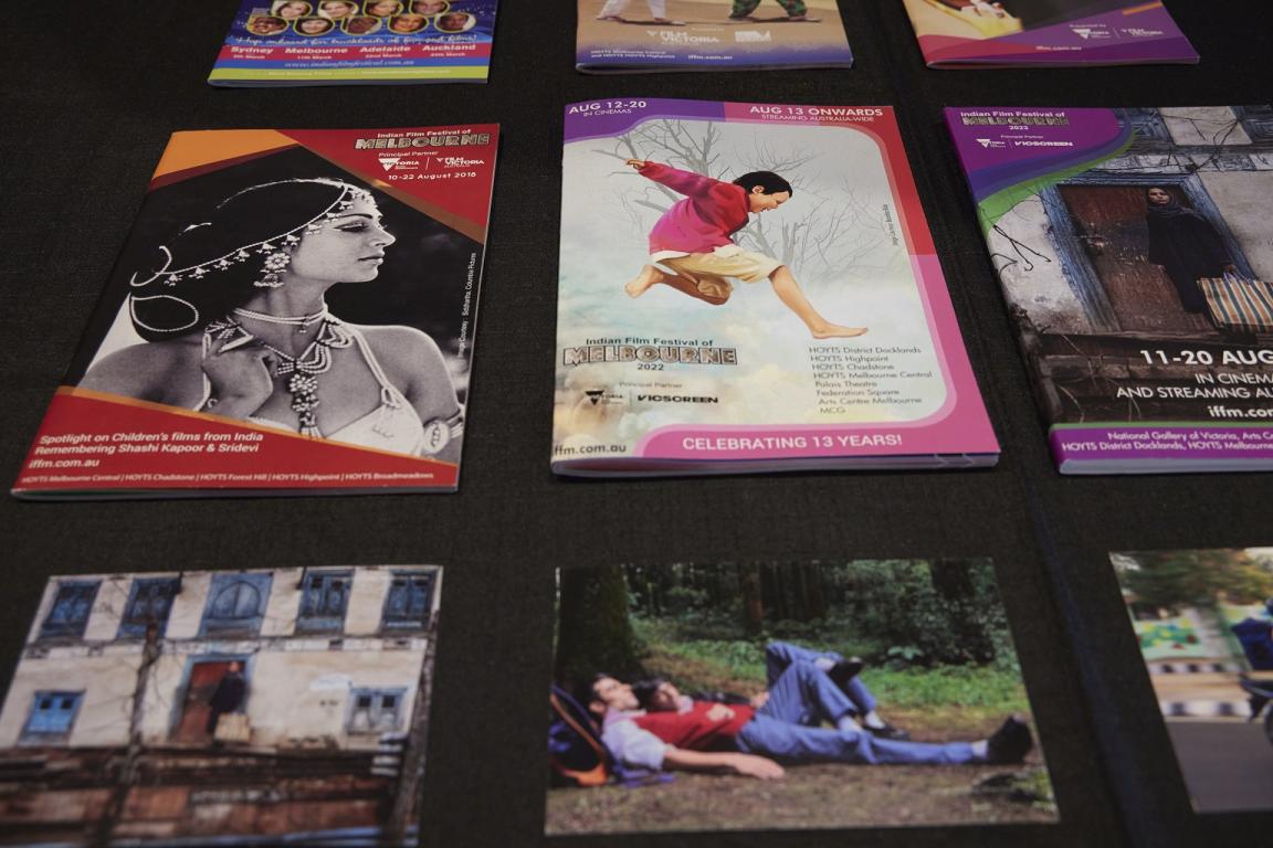 Brochures from various years of the Indian Film Festival of Melbourne on a black surface